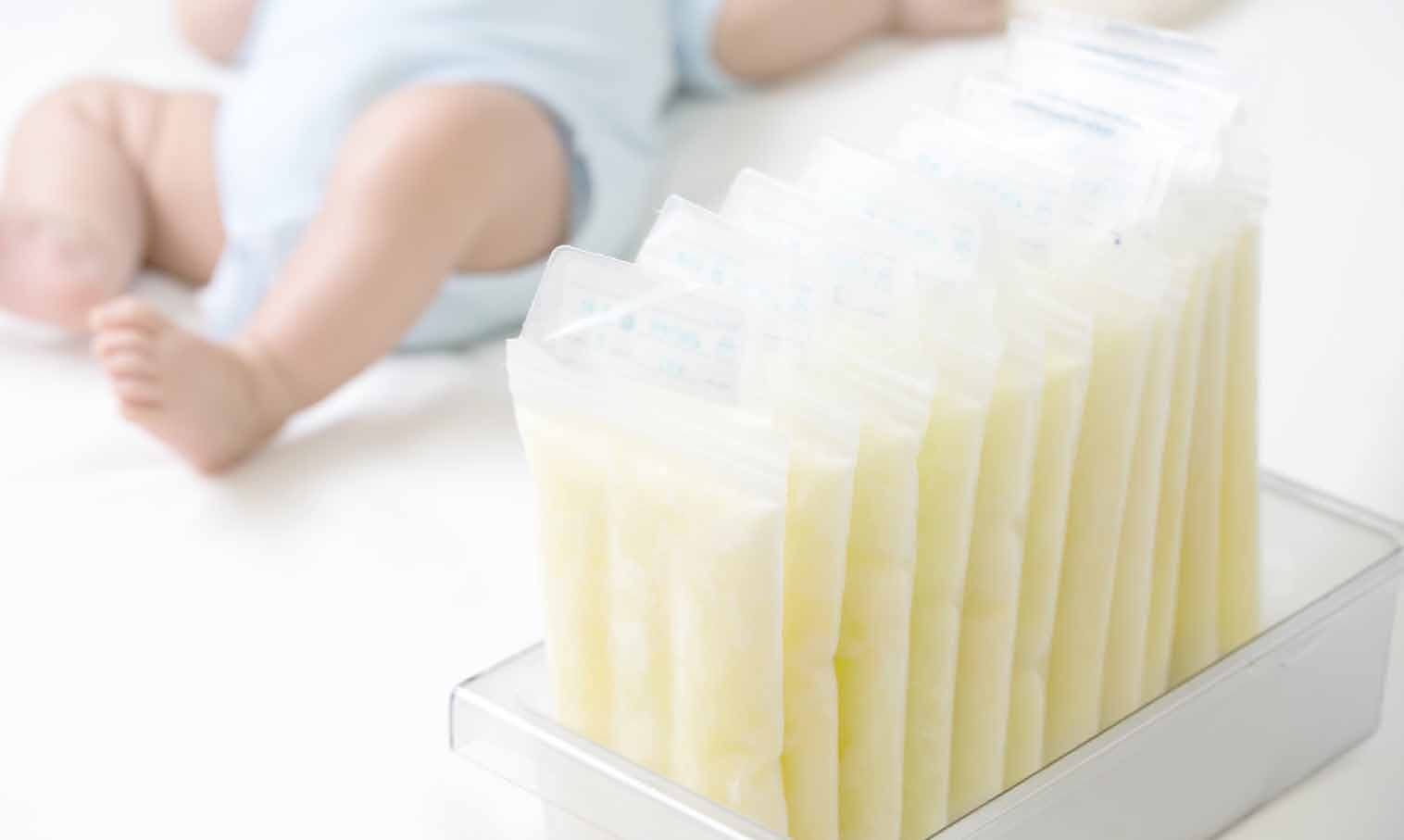 Frozen breast milk donation bags beside a baby